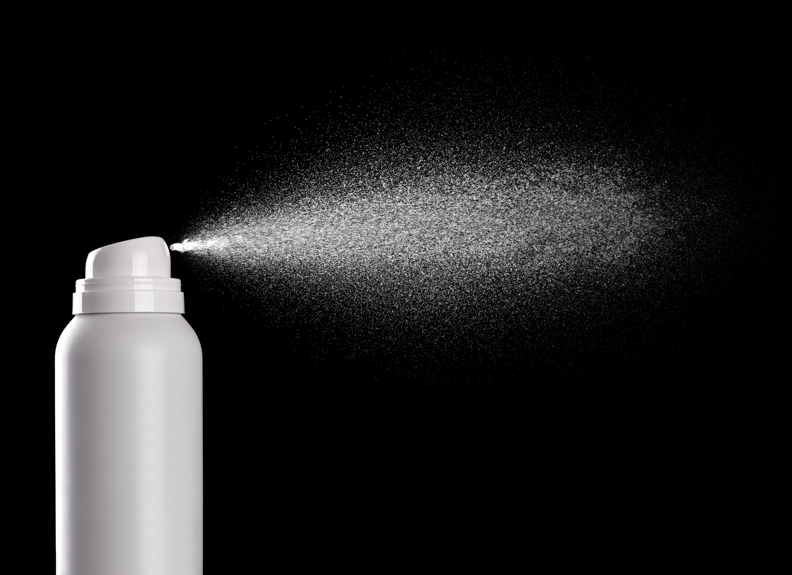 white aerosol can sprays in front of black background
