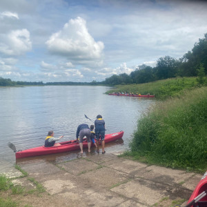 Teilnehmende der UBAwegs Tour im Mai steigen für die Paddeltour in ein Boot ein