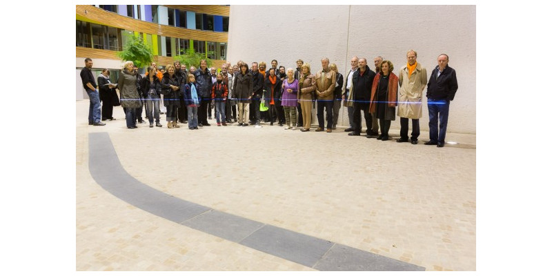 Im Atrium des UBA Dessau steht eine Gruppe von Personen. Etwa in Hüfthöhe zeigt ein blauer Laser den Stand des Wasserpegels.