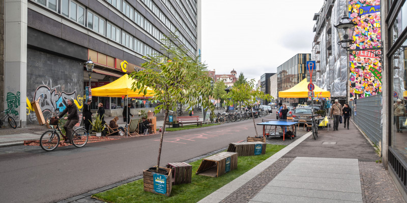 Randstreifen einer Straße ist von Sitzgruppen belegt