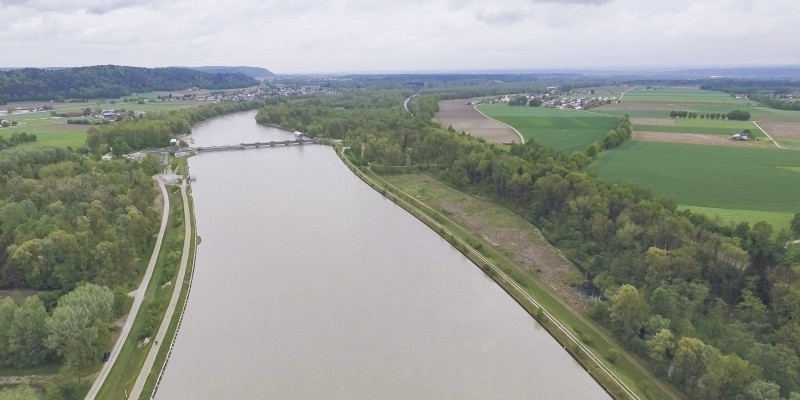 Luftbild des aufgestauten, strukturarmen Inns mit Wasserkraftwerk Stammham im Hintergrund.