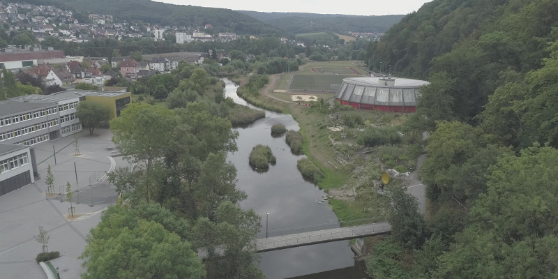 Luftbild der renaturierten Ruhr, links ein Schulhof, rechts eine Erlebnisraum und Sportanlage.