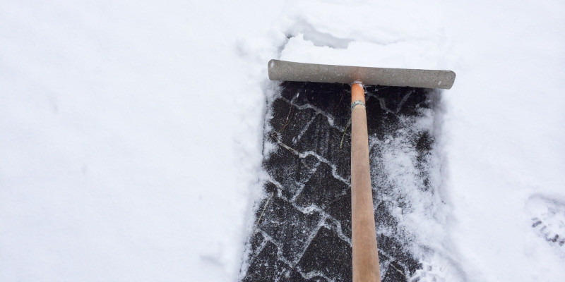 Schnee auf Gehweg wird weggeschippt