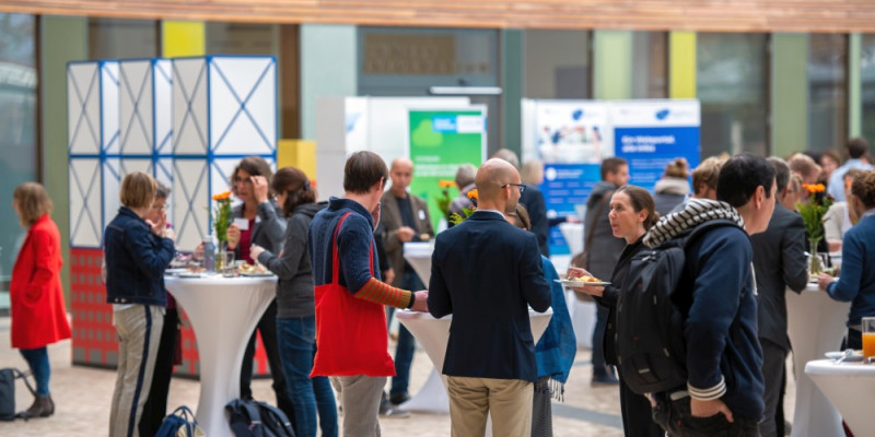 Menschen und Stände im UBA Foyer