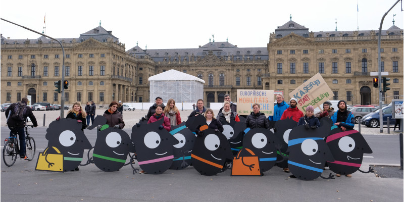 Teilnehmende stehen hinter den Maskottchen, die sie getragen haben.