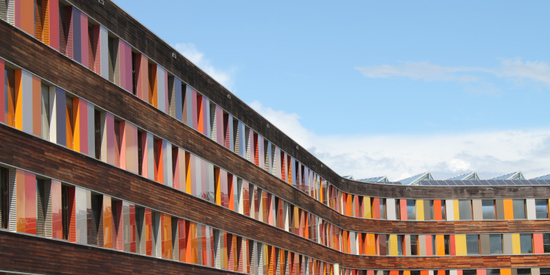 Rear wood façade of UBA office building in Dessau-Roßlau with glass slabs in different shades of red