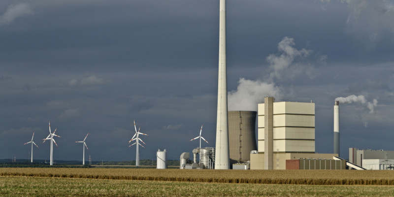 power plant with smoking chimney and wind power plants