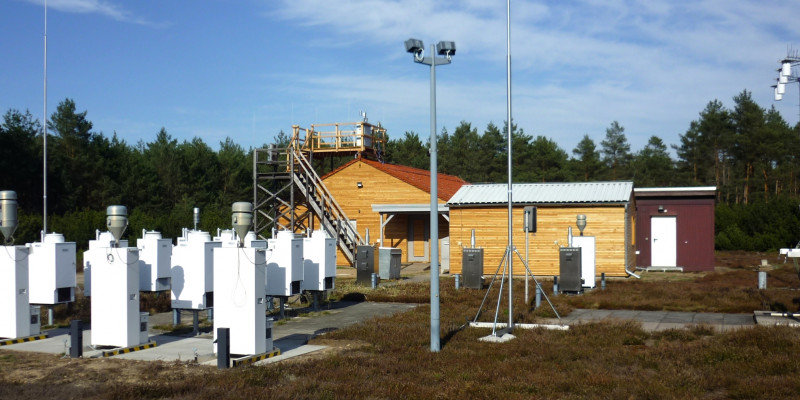 Outdoor observation area, two small buildings of light-coloured wood in the background