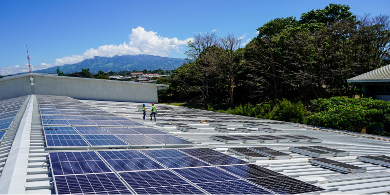 A photovoltaic system is installed on the roof of a warehouse