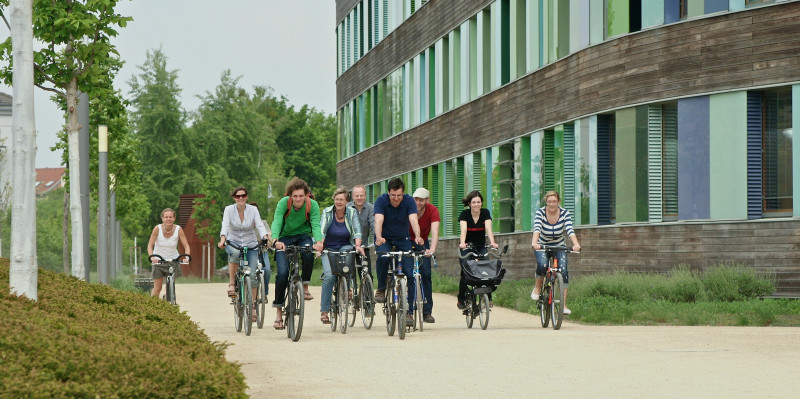 fröhliche Fahrradfahrerinnen und Fahrradfahrer vor dem UBA Dessau