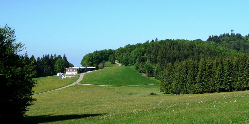 Building of the air quality measuring station in hilly landscape with fields and spruce forest