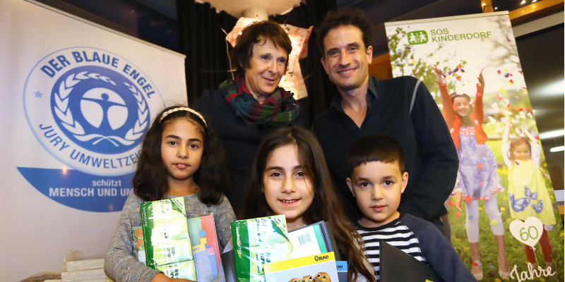Gruppenfoto: Maria Krautzberger, Oliver Mommsen und drei Kinder mit Kinderheften, Taschentücher-Paketen und anderen Produkten im Arm
