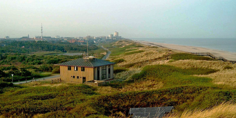 kleiner, zweistöckiger Holzbau in den Dünen