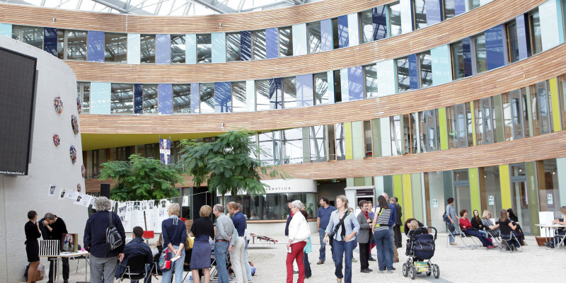 Besucher sehen sich die Kunstausstellung "Der Weg eines T-Shirts rund um den Globus" im Atrium im UBA Dessau an.
