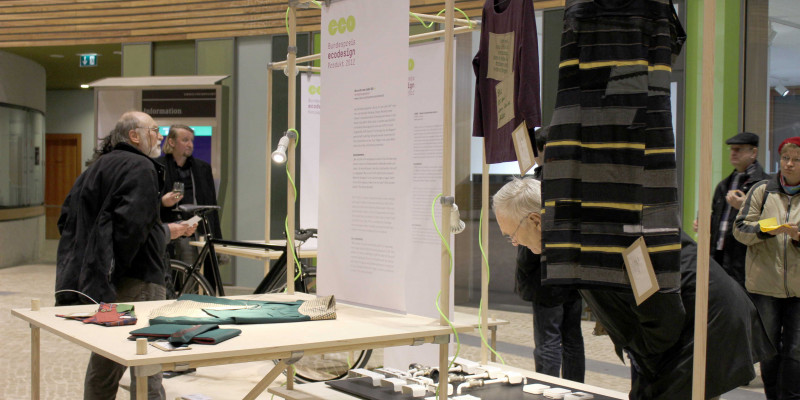 Besucher der Wanderausstellung sehen sich einen Stand im Atrium im UBA Dessau an.