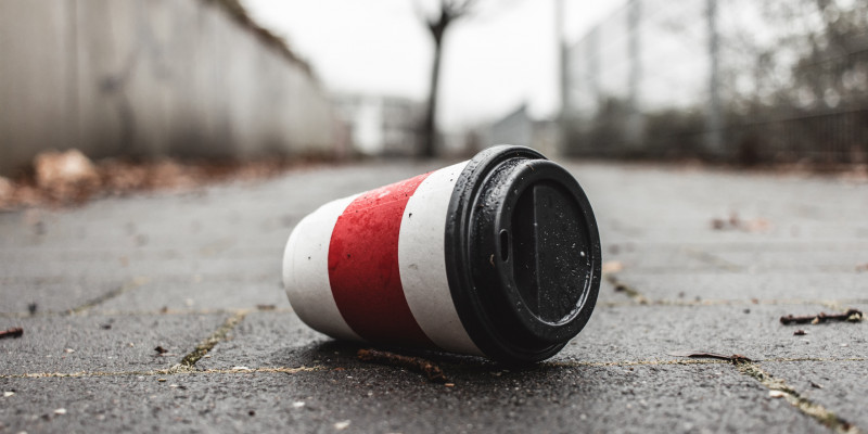 Ein Coffee-to-go-Becher liegt auf der Straße