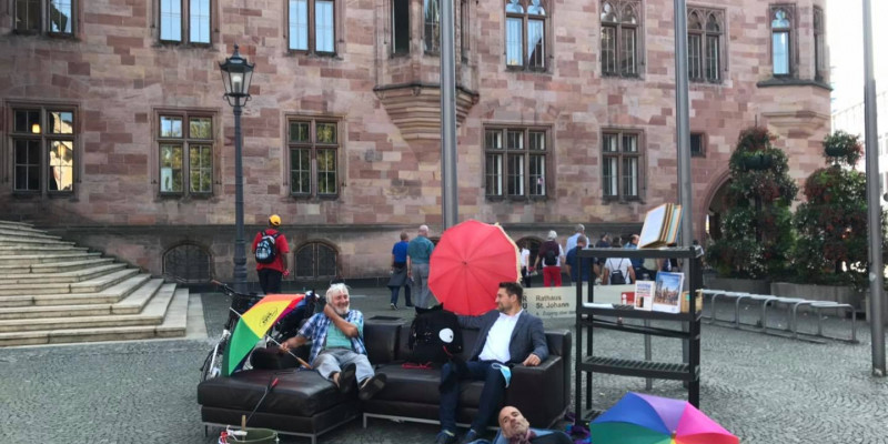 Couch mit Menschen auf dem Marktplatz