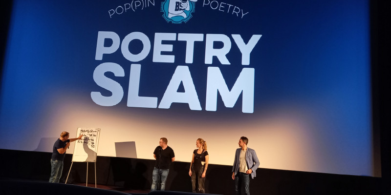Menschen auf der Bühe beim Poetry Slam