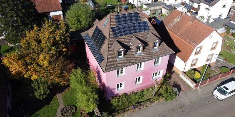 Ein rosarotes Wohnhaus von oben.