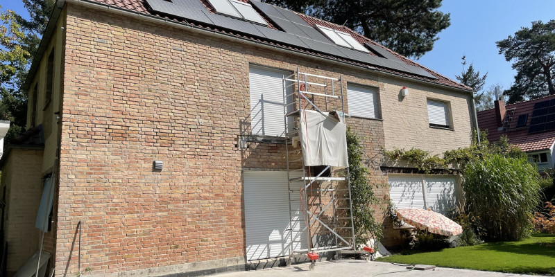 Ansicht des zweistöckigen Hauses von der Straße her. Auf dem Dach sind Photovoltaik-Module zu sehen.