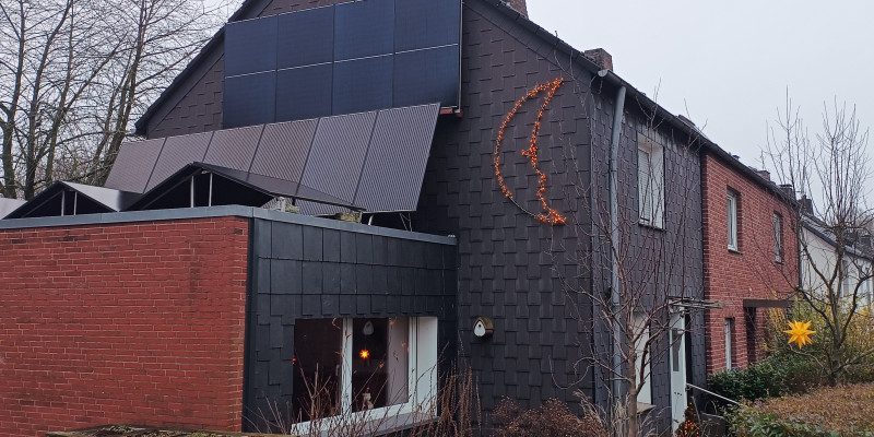 Ein schieferverkleidetes Reihenendhaus mit einstöckigem Anbau an der Giebelseite