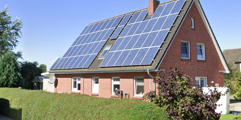 Ein geklinkertes Haus mit Photovoltaik auf dem Dach.