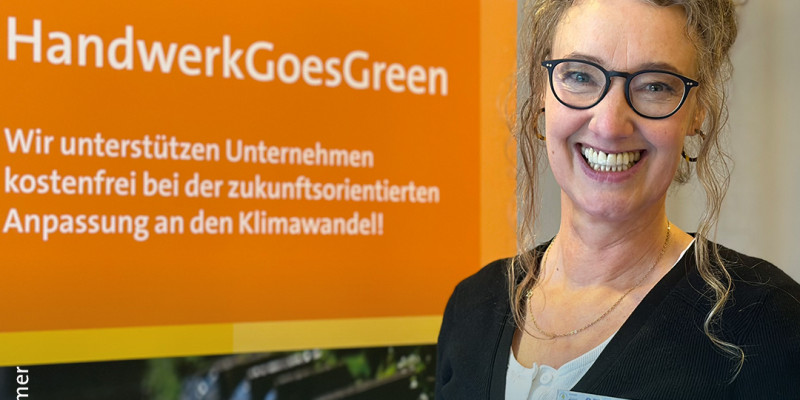 Veranstaltung zum Thema klimaangepasstes Bauen mit Handwerksbetrieben. Nina Wood steht vor dem Veranstaltungslogo.