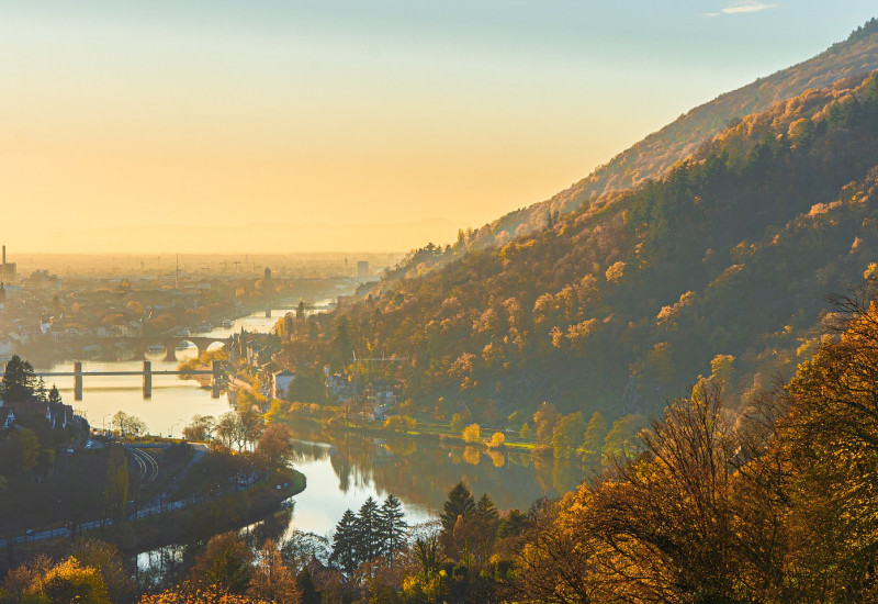 Das Bild zeit eine Landschaft mit Fluss und Bergen im Herbst