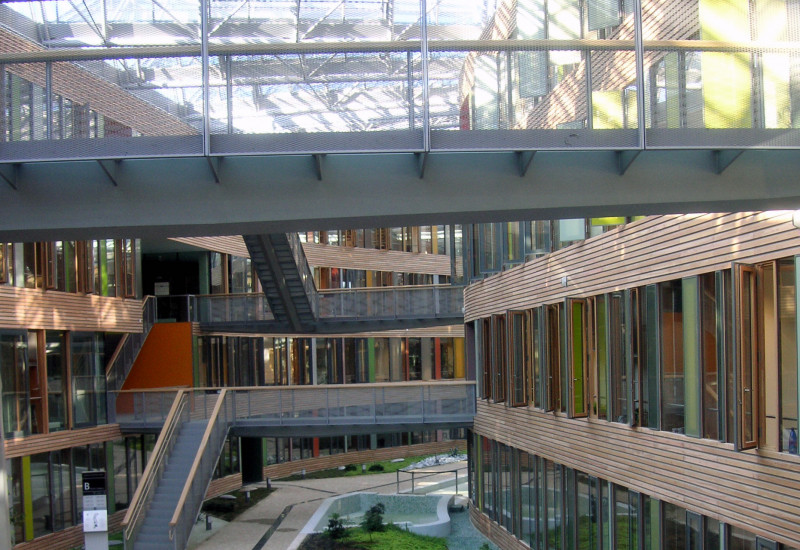 atrium with a glass roof, bridgesElongated inner courtyard with glass roof, skywalks linking two sides of the building, greenery and water basin