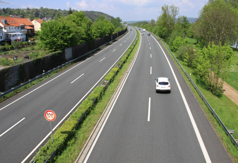 Auto auf einer Autobahn mit einem "Tempo 120"-Schild