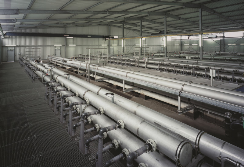 in einer Leichtbauhalle mit einem Boden aus Metallgittern steht eine große Anlage aus einem Rohrsystem