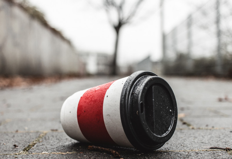 Ein Coffee-to-go-Becher liegt auf der Straße