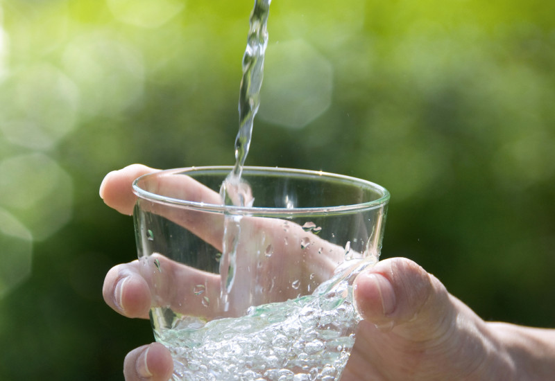 A hand holding a water glass can be seen. 