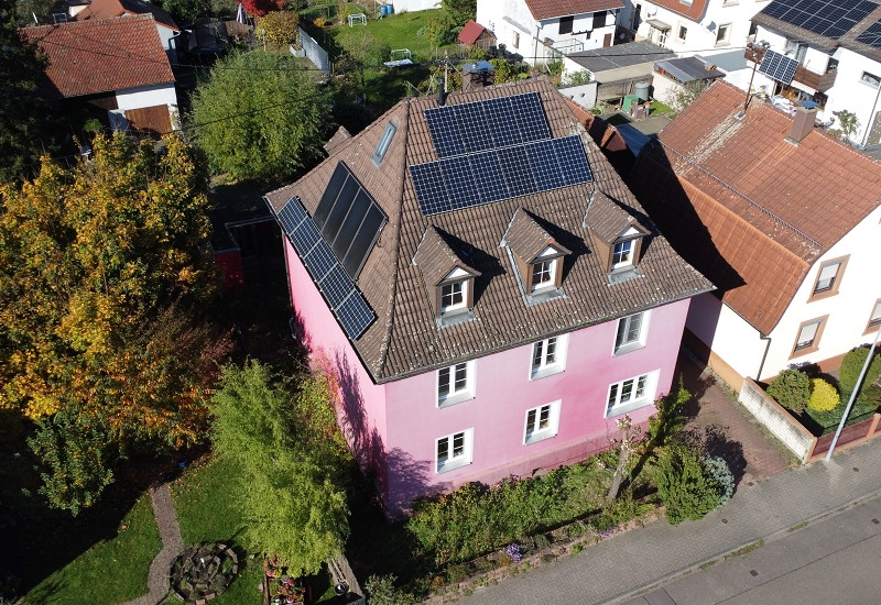 Ein rosarotes Wohnhaus von oben.