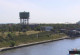 Ein großes Containerschiff fährt bei Sonnenschein auf dem Rhein