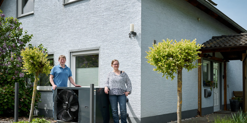 Familie Krüger vor Ihrem Haus mit Wärmepumpe