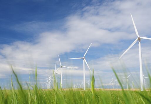 weißer Windpark vor blauem Himmel mit Schönwetterwolken, vor die Kulisse ragen g